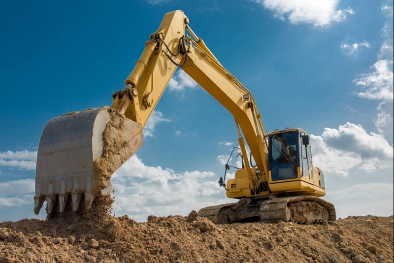 Large yellow excavator on a construction site on a sunny day